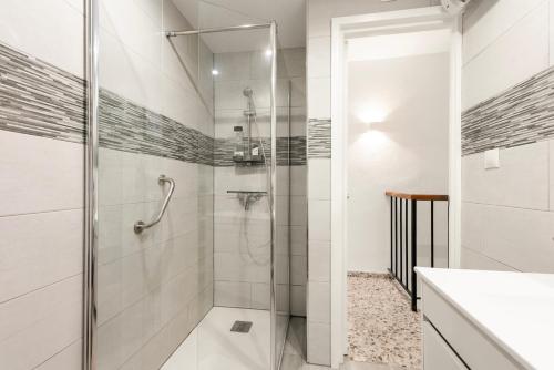 a white bathroom with a shower and a sink at Casa Coral Beach in Málaga