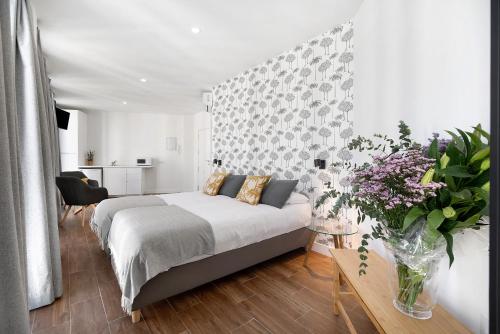 a bedroom with a bed and flowers in a room at Casa Milano 2 in Jerez de la Frontera