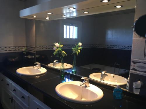 a bathroom with three sinks and a large mirror at Casa Paula in Yaiza