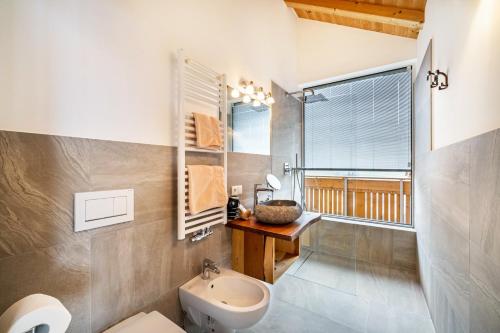 a bathroom with a sink and a toilet and a window at Eggerhof Fernblick in Verano