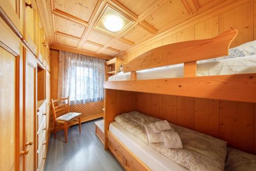 a bedroom with two bunk beds in a cabin at Appartamento Padola 72 in Padola
