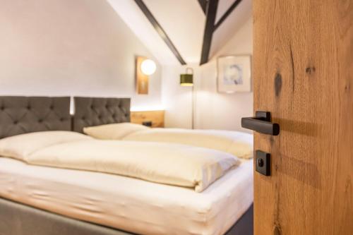 a bedroom with two beds with white sheets at Residence Skutial App Schlern in Castelrotto