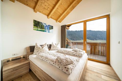 a bedroom with two beds and a large window at Eggerhof Fernblick in Verano