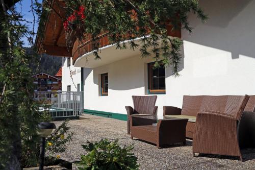 a patio with chairs and tables in front of a building at Hotel & Suites Glück Auf in Mayrhofen