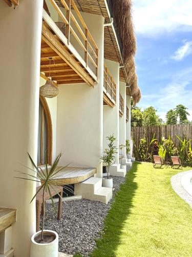 a patio with a bench and a grass yard at Laya Boutique Hotel in General Luna
