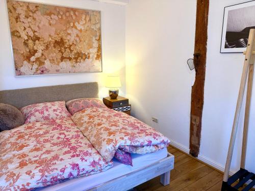 a bedroom with a bed and a table with a lamp at Lüttje Reethuus in Südbrookmerland