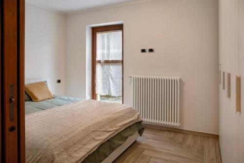 a bedroom with a bed and a window at La Casetta Chiesa Valmalenco in Chiesa in Valmalenco