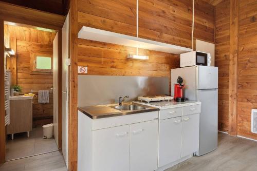 a kitchen with a white refrigerator and a sink at Chalet confort 20 in Saint-Gervais