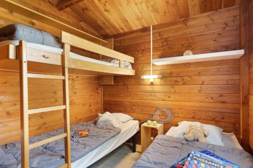 two bunk beds in a room with wooden walls at Chalet confort 20 in Saint-Gervais