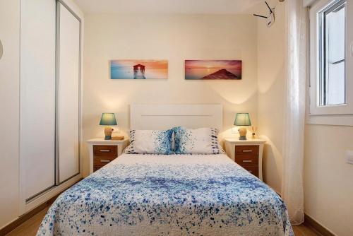a bedroom with a bed and two lamps and a window at Casa Orilla Sur B in El Palmar