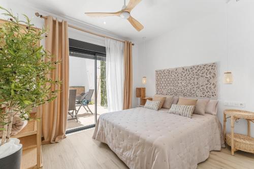 a white bedroom with a bed and a balcony at Casa Catral Alfalfar 12 in Catral