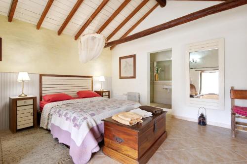 a bedroom with a bed with red pillows and a table at Casa de Campo in Betancuría