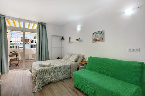 a bedroom with a green couch and a bed at Estudio Sagrario in Arona