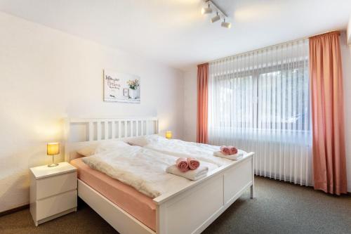 a bedroom with a white bed with two towels at Ferienwohnung Tannenberg in Diemelstadt 
