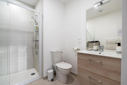 a bathroom with a toilet and a shower and a sink at Regard Marin - Appartement 4 pers in Le Palais