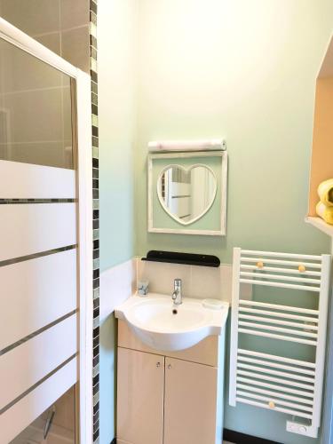 a bathroom with a sink and a mirror at Petit Gîte Douillet L'abri Côtier in Saint-Léonard