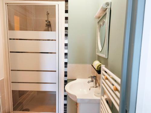 a bathroom with a sink and a shower at Petit Gîte Douillet L'abri Côtier in Saint-Léonard