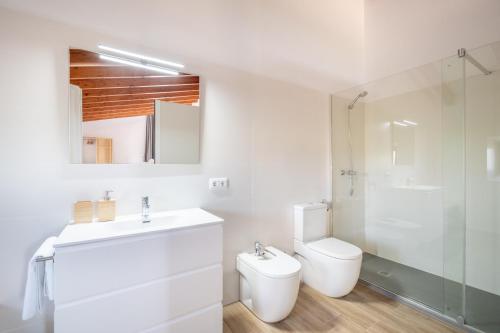 a white bathroom with a toilet and a sink at Son Guillem in Son Sardina