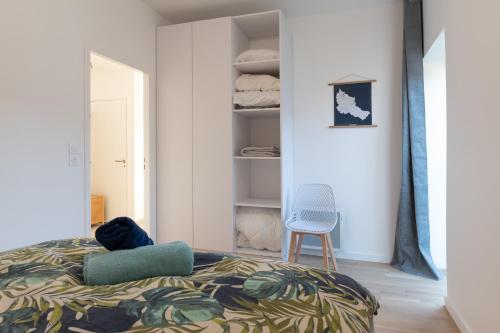a bedroom with a bed and a blue chair at Regard Marin - Appartement 4 pers in Le Palais