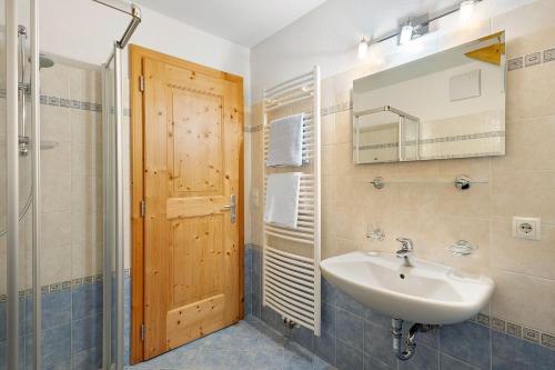ein Badezimmer mit Waschbecken, Dusche und Spiegel in der Unterkunft Rungghof in Wengen