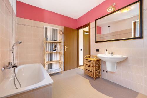 a bathroom with a white tub and a sink at Katzemburg 9999 in Arco