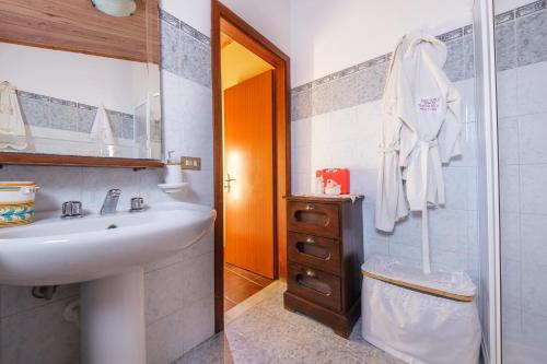 a white bathroom with a sink and a shower at Holiday Home Tommaso e Martina in Savoca