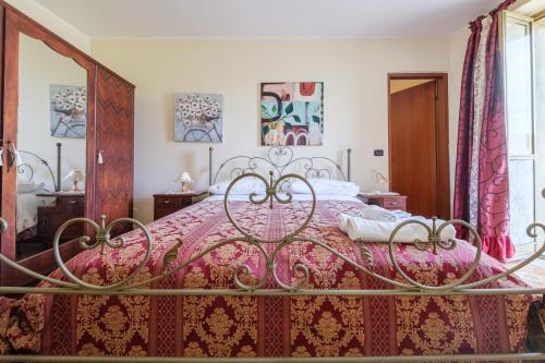 a bedroom with a bed with a pink bedspread at Holiday Home Tommaso e Martina in Savoca