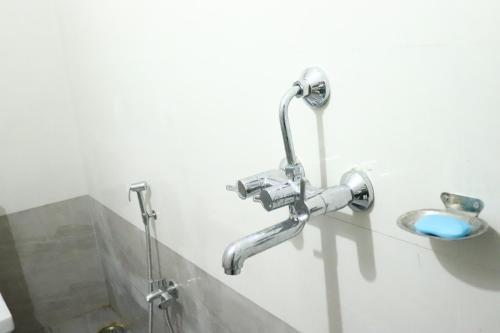 a bathroom with a faucet and a sink at Hotel Golden Mahseer in Tezu
