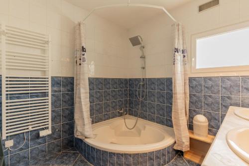 a bathroom with a tub and a sink at Maison maxi 8 personnes, proche mer in Mers-les-Bains