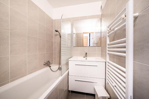 a white bathroom with a sink and a mirror at Appart 6 pers – Accès direct Ski in Morillon