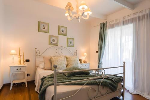 a bedroom with a bed and a chandelier at Villetta Antonia in Marina di Andora
