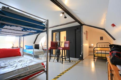 a room with two bunk beds and a table at Guidon Fourchette et table d'hôtes in Saint-Bonnet-de-Salers