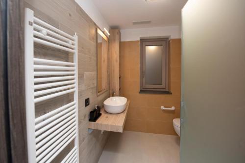 a bathroom with a sink and a toilet and a mirror at Appartamenti Suly 5 - Cir 0086 in Saint Vincent