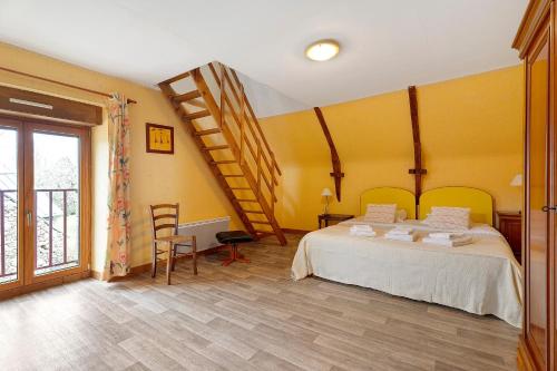 a bedroom with a large bed and a staircase at Gite Hirondelle in Lanvallay