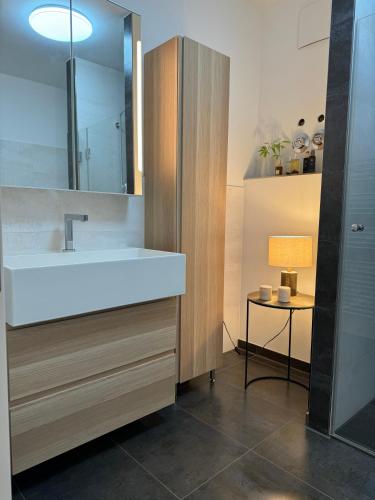a bathroom with a white sink and a lamp at 180qm Penthouse mit Sonnenterrasse in Rostock