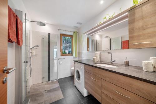 a bathroom with a sink and a washing machine at Waldheim in Verano