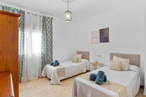 a white room with two beds and a chair at Apartamento Centro de Marbella in Marbella