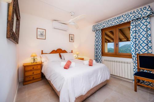 a bedroom with a large white bed and a window at Villa Carla in Port de Soller