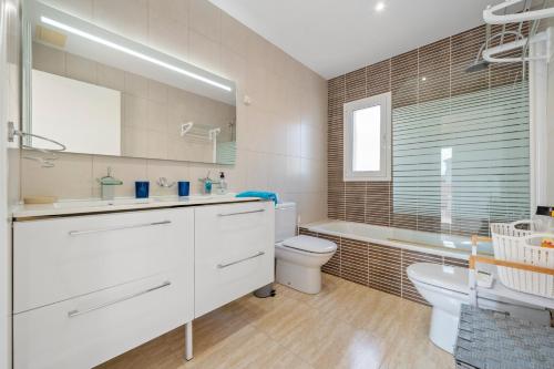 a white bathroom with a toilet and a sink at Las Palmeras in Tarragona