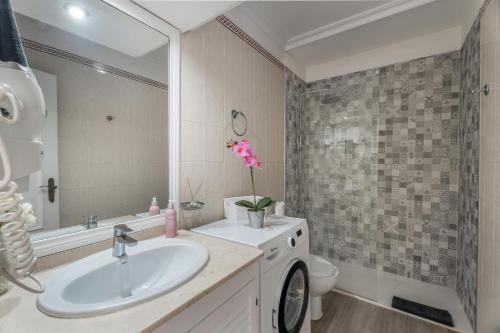 a bathroom with a sink and a toilet and a mirror at Oasis del Sur in San Miguel de Abona