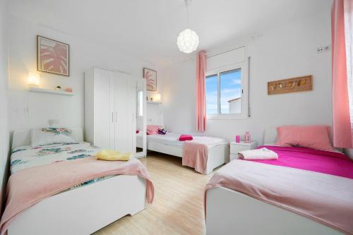 a bedroom with two beds and a window at Las Palmeras in Tarragona