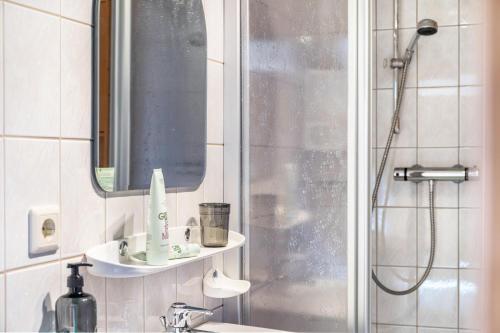 a bathroom with a shower and a sink and a mirror at Sonnenhütte Wildschönau Erdgeschoß in Grafenweg