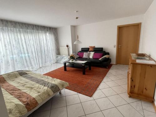 a living room with a bed and a couch at Ferienwohnung - Haus Waibel in Überlingen