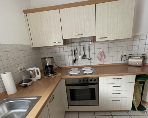 a kitchen with a sink and a stove top oven at Ferienwohnung - Haus Waibel in Überlingen