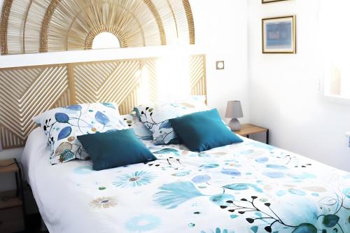 a bed with blue and white sheets and pillows at Le Gite De La Colline in Nérac