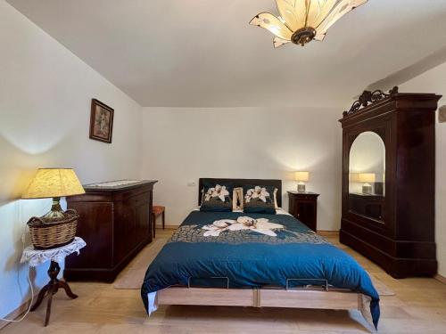 a bedroom with a bed with a blue comforter at L’Angelina in Martrin