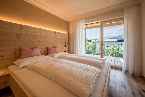 a bedroom with a large bed and a large window at Sommersbergerhof 1968 in Bressanone