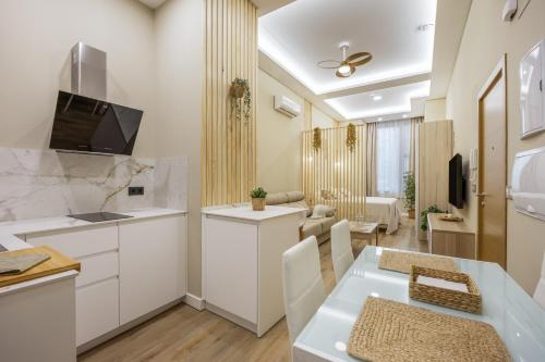 a kitchen and living room with white cabinets and a table at Apartamentos Brisas de Cádiz 3 in Cádiz