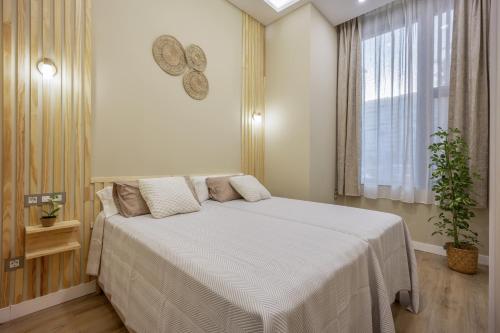 a bedroom with a large bed with a window at Apartamentos Brisas de Cádiz 3 in Cádiz