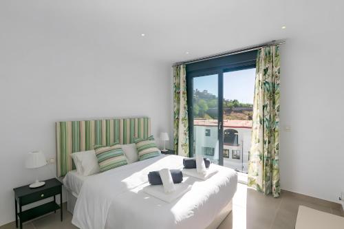 a bedroom with two beds and a large window at Stunning apartment in Cómpeta in Cómpeta